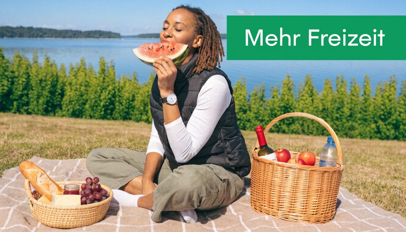 Eine Frau genießt eine Wassermelone bei einem entspannten Picknick im Freien am Seeufer mit einer schönen Aussicht.