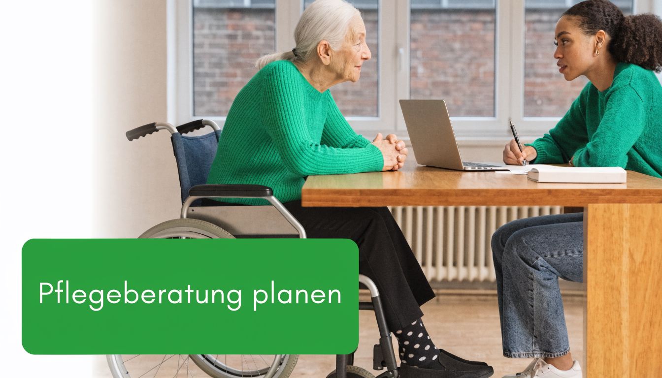 Eine junge Pflegerin berät eine ältere Dame im Rollstuhl bei einem gemeinsamen Gespräch am Schreibtisch.