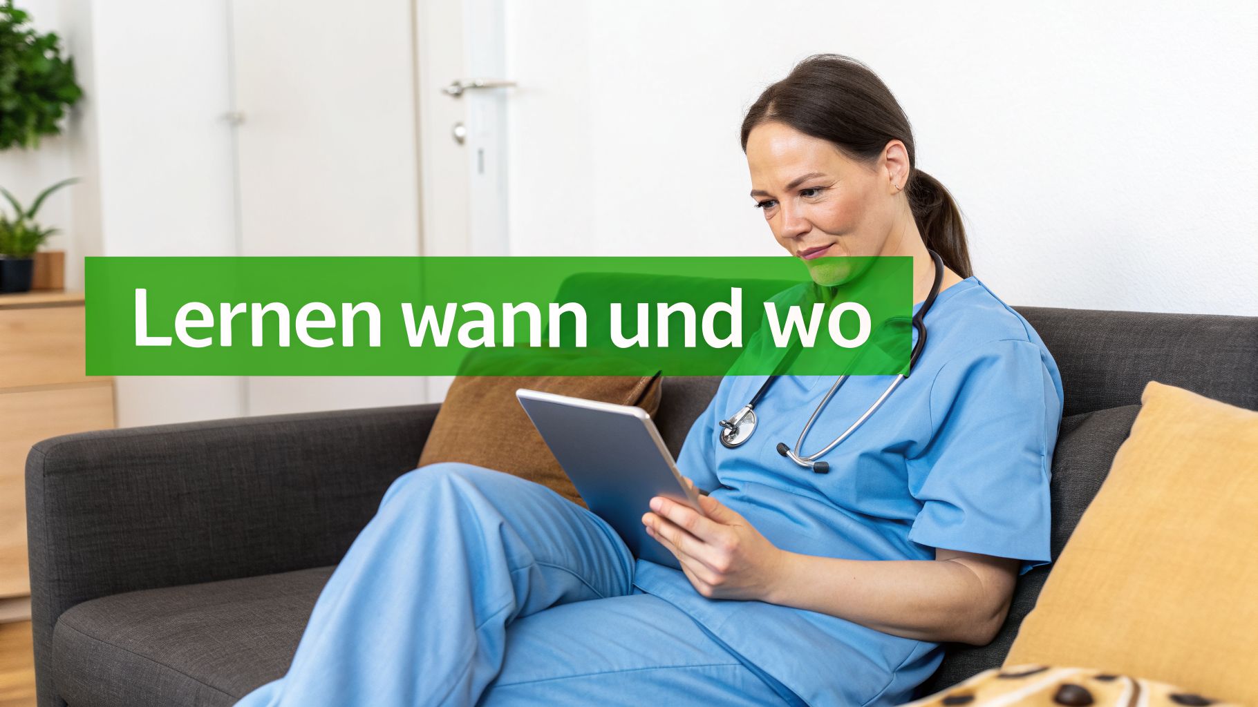 Eine Pflegefachkraft in blauer Uniform sitzt entspannt auf einem Sofa und lernt mit einem Tablet, jederzeit und überall.