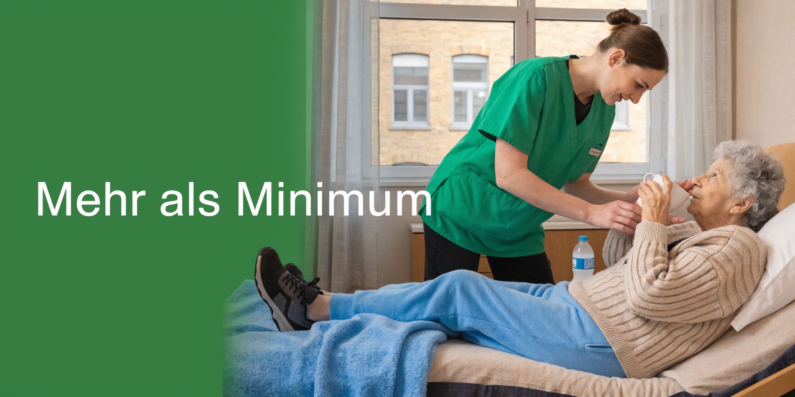 Eine Pflegekraft hilft einer bettlägerigen älteren Dame beim Trinken aus einem Becher in einem hellen Pflegezimmer.