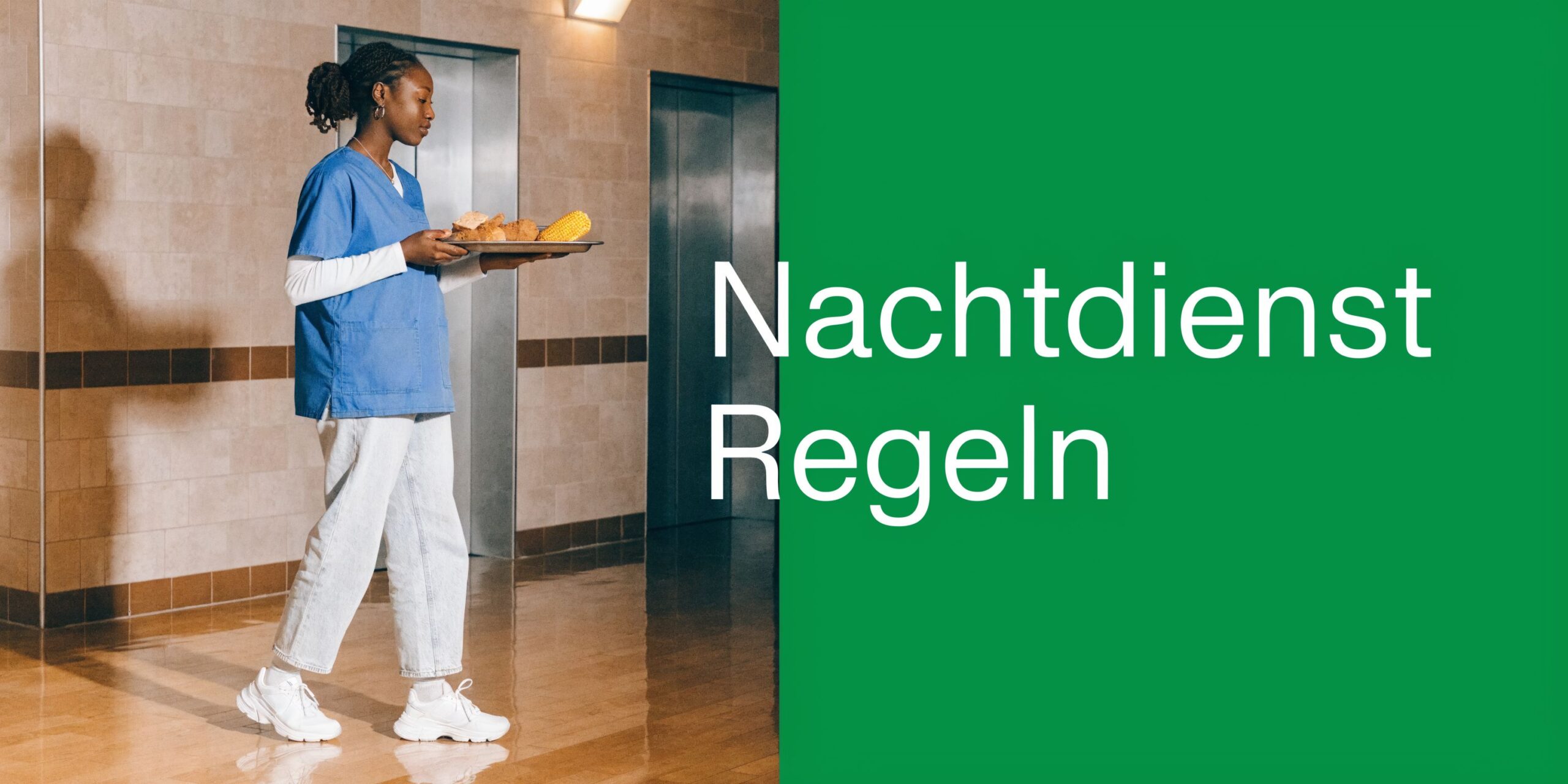 Eine Pflegekraft in blauer Arbeitskleidung trägt ein Tablett mit Essen durch einen Krankenhausflur während der Nachtschicht.