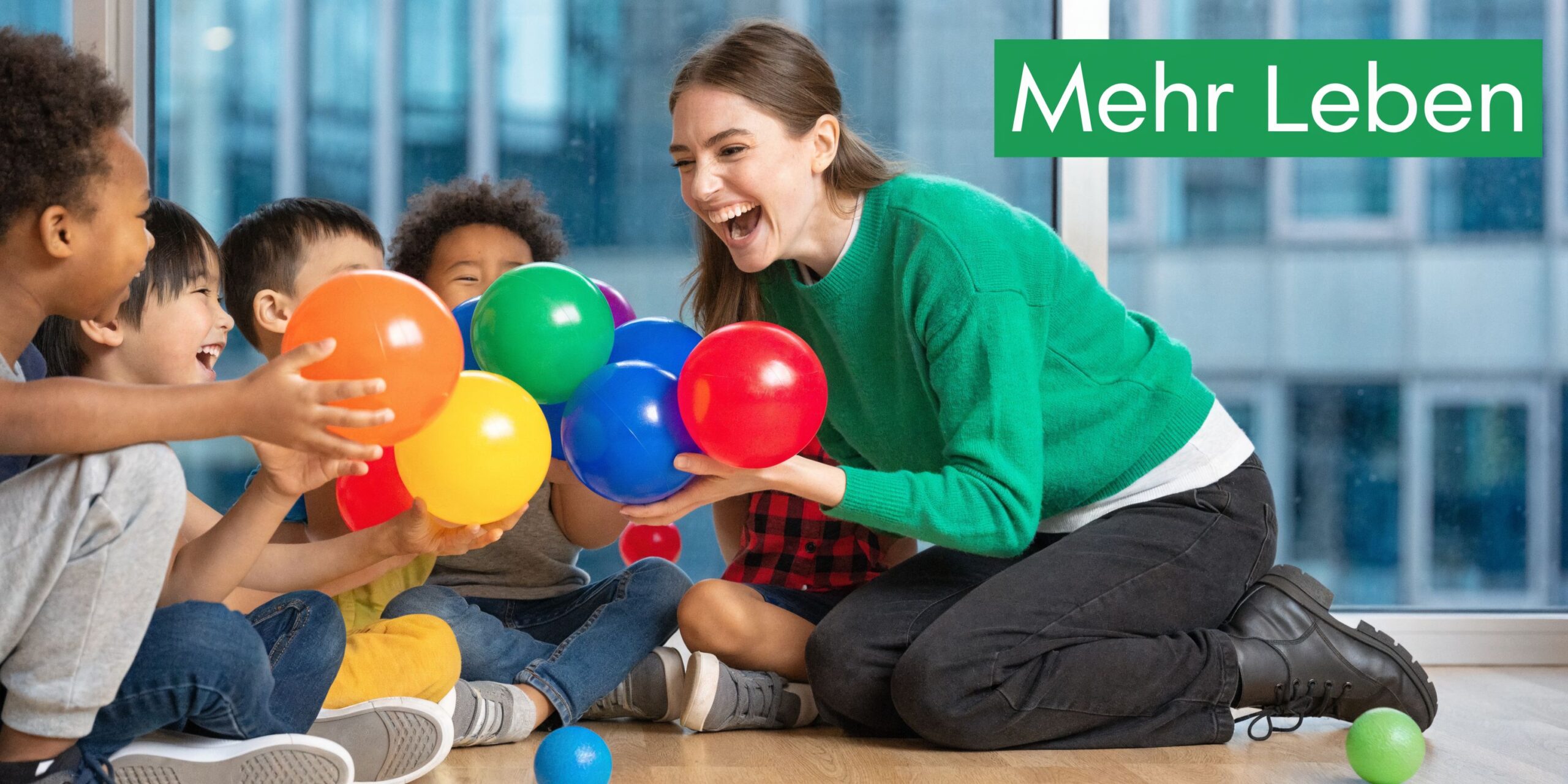 Eine fröhliche Erzieherin spielt mit Kindern und bunten Bällen in einer hellen Kita-Umgebung