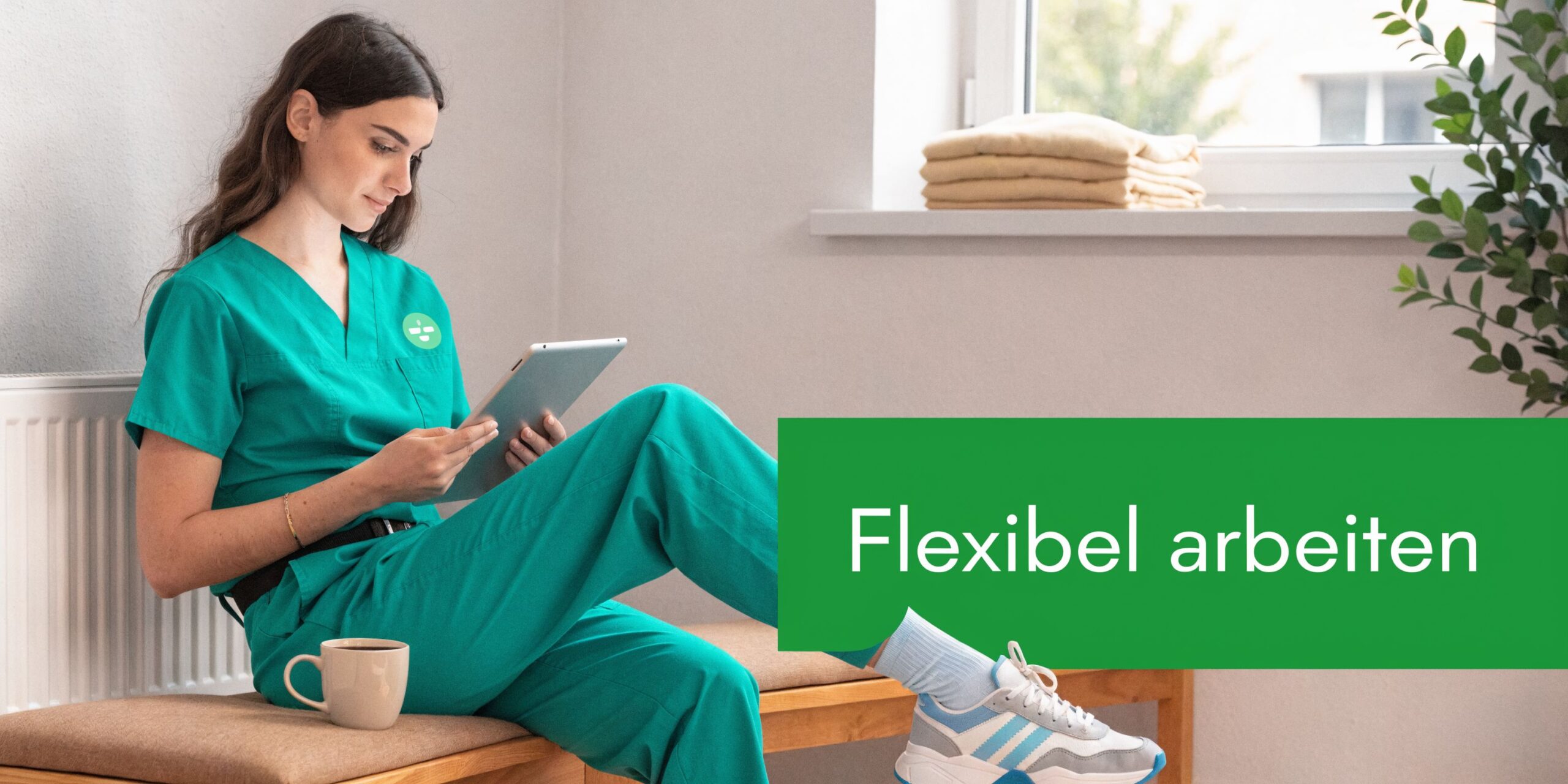 Eine junge Frau in medizinischer Arbeitskleidung sitzt auf einer Bank und liest entspannt auf ihrem Tablet.