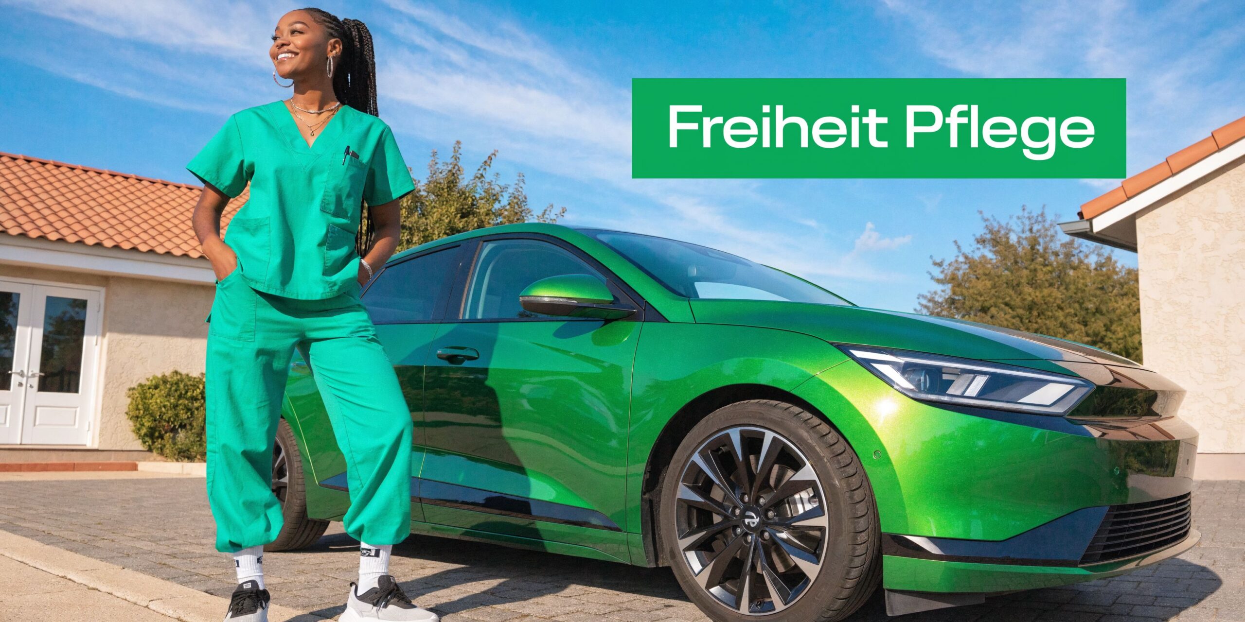 Eine professionelle Pflegekraft in grüner Arbeitskleidung steht stolz neben ihrem glänzenden grünen Firmenwagen vor einem Wohnhaus.