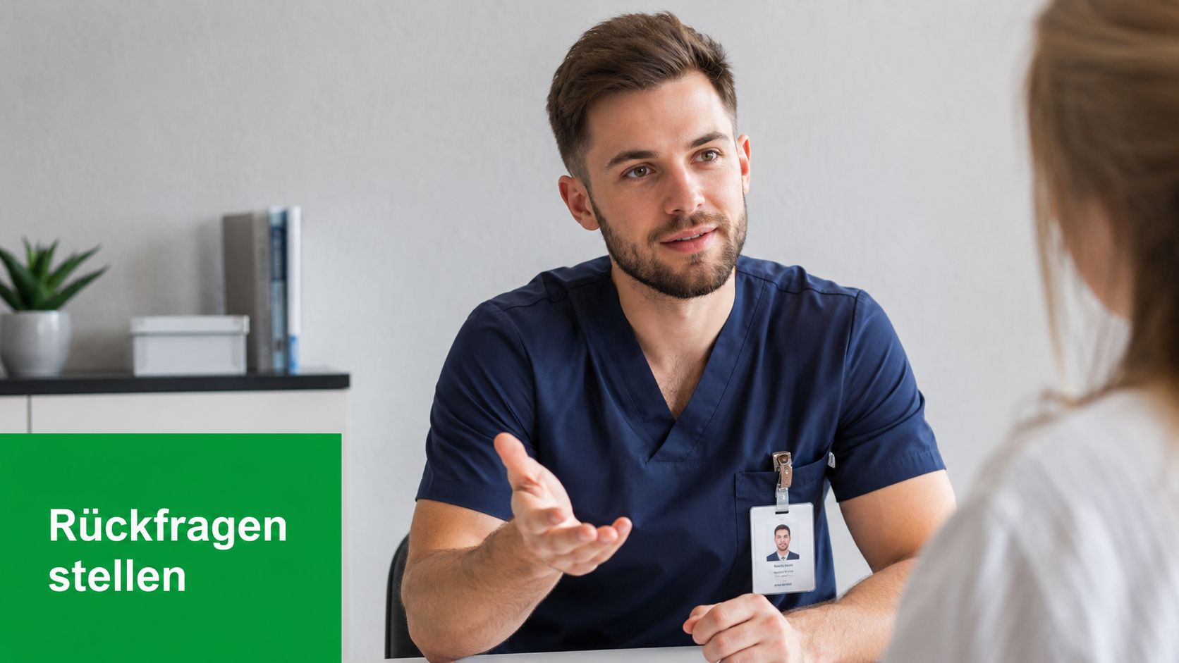 Ein männlicher Pflegefachkraft im Vorstellungsgespräch sitzt am Schreibtisch und spricht freundlich mit einer Bewerberin.